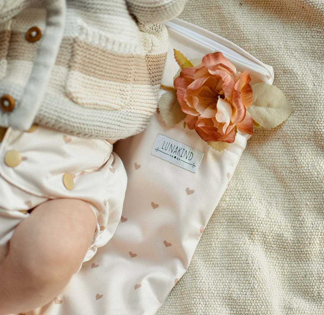 Baby mit Lunakind Stoffwindel auf Lunakind Wetbag mit Herzen